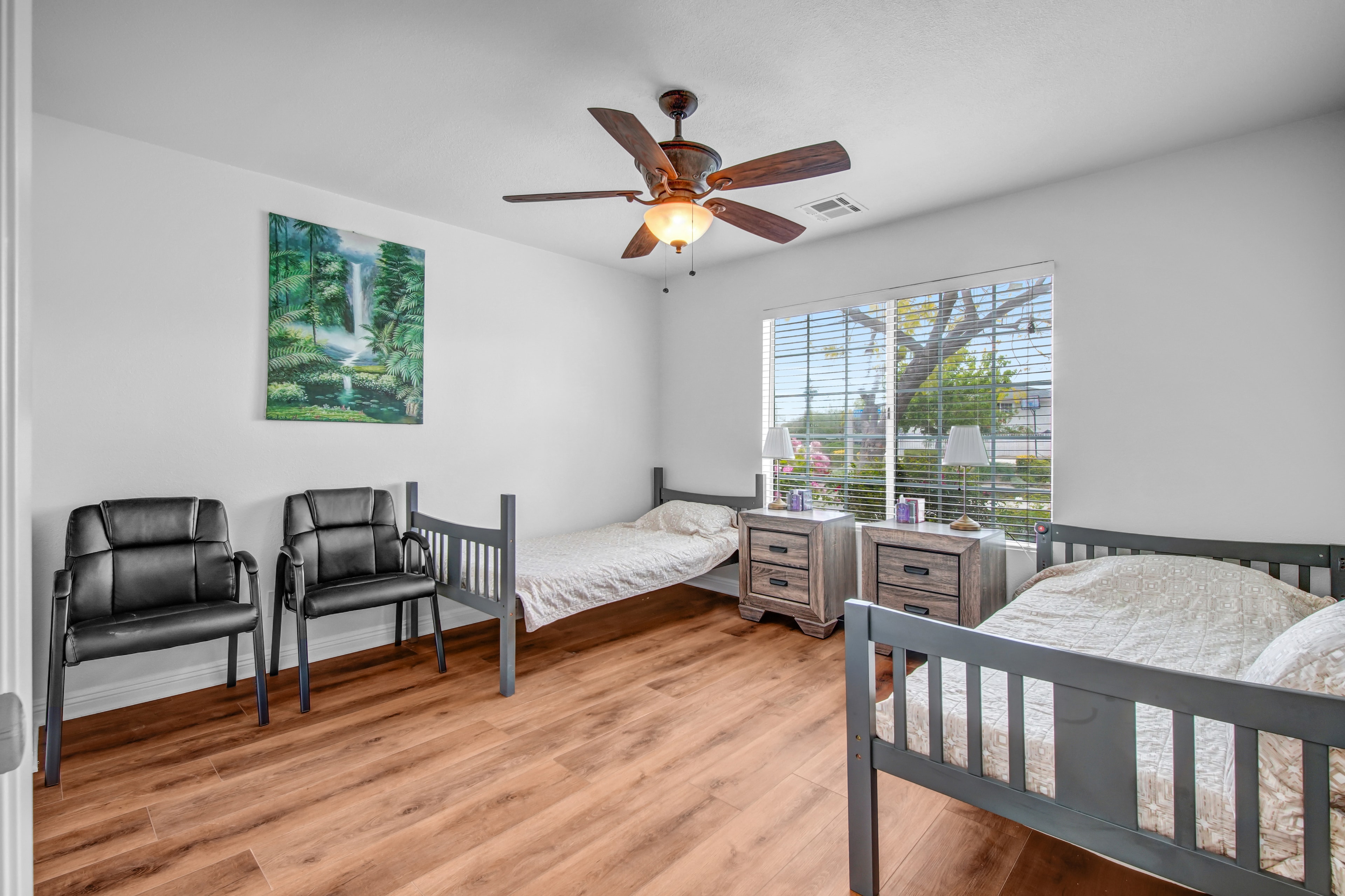 Spacious bedroom with hardwood floors and garden view